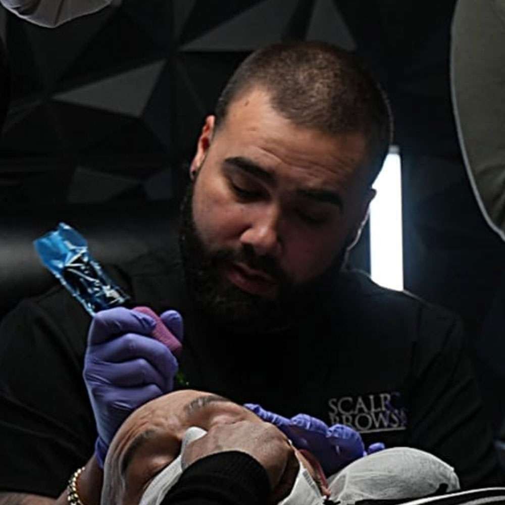 Anthony, lead SMP educator at Scalp and Brows NJ, guiding students through advanced scalp micropigmentation techniques during hands-on training.