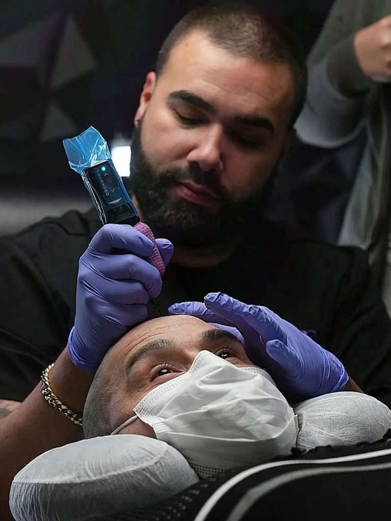 Anthony performing scalp micropigmentation treatment on a client at Scalp and Brows NJ.